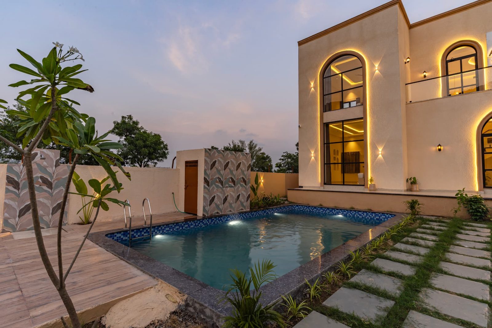 Poolside view of Alora Woods Villa at sunset