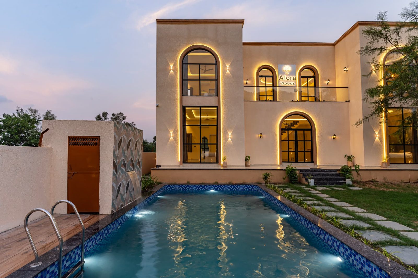 Illuminated villa facade reflected in the swimming pool